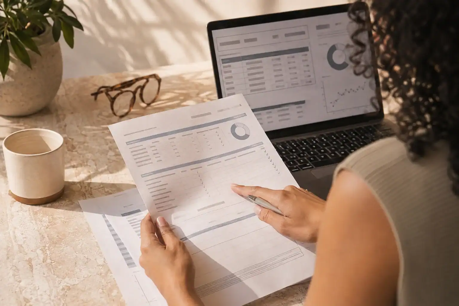 Person comparing a printed laboratory report with batch information on a laptop