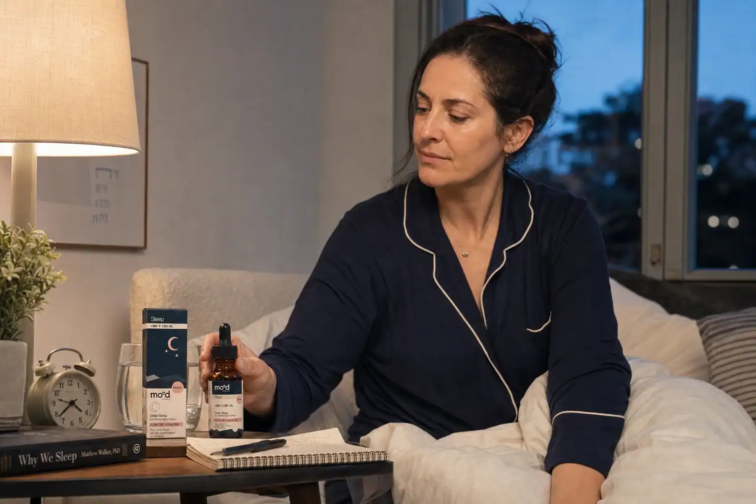 A woman records her evening sleep routine beside Mood Wellness Deep Sleep oil
